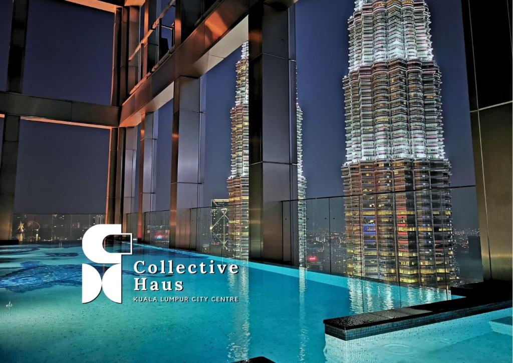 a view of a skyscraper from a swimming pool at night at Tropicana Residences Kuala Lumpur by Collective Haus in Kuala Lumpur