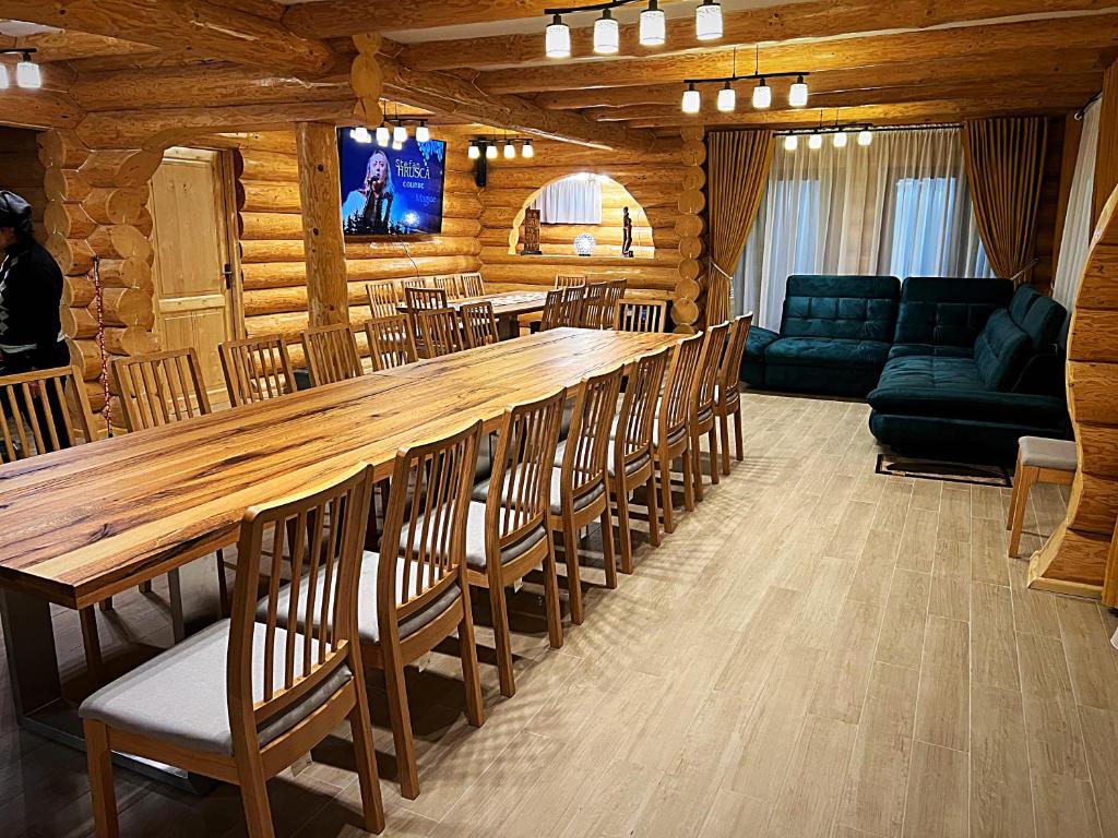 LeordinaにあるPensiunea Casa Cătanelorの長いテーブルと椅子が備わる広い客室です。