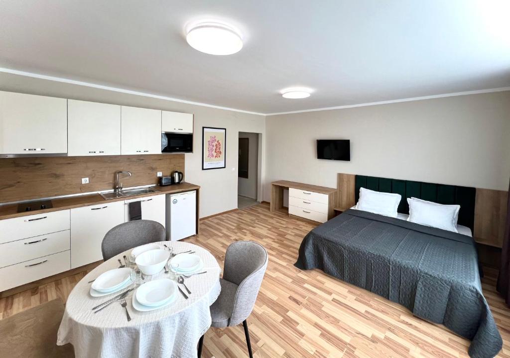 Sineva Del Sol Apartments في سفيتي فلاس: غرفة نوم بسرير وطاولة مع كراسي