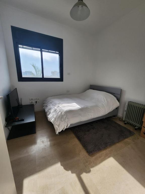 a bedroom with a bed and a window at penthouse in Herzliya
