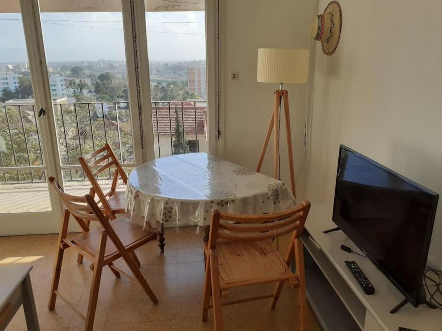 The Seaview في الجزائر: غرفة معيشة مع طاولة وكراسي وتلفزيون