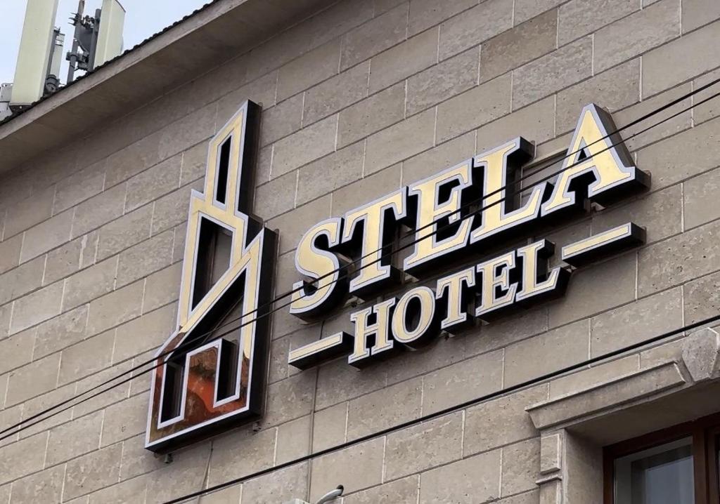 una señal de hotel en el lateral de un edificio en Stela Hotel, en Shymkent