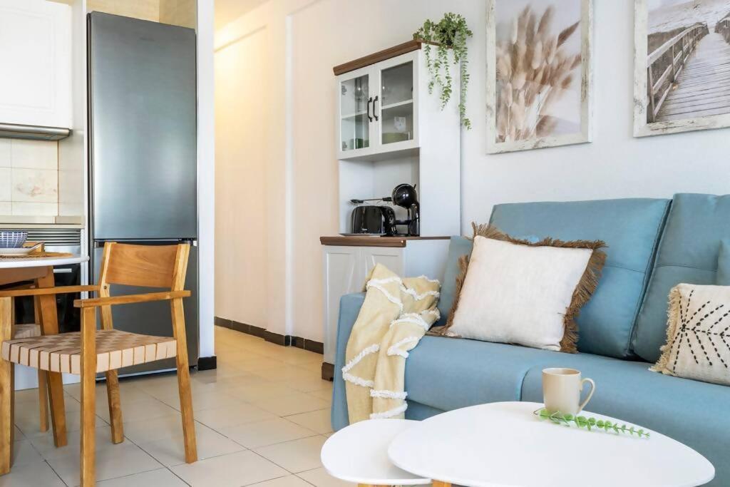Una sala de estar con un sofá azul y una mesa. en Bungalow Pink Torreblanca, en Torrevieja