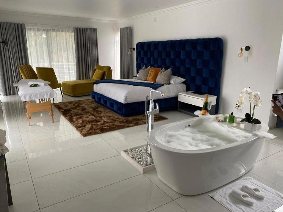 ein Badezimmer mit einer Badewanne und ein Schlafzimmer mit einem Bett in der Unterkunft Letaba Boutique Hotel and Spa in Giyani