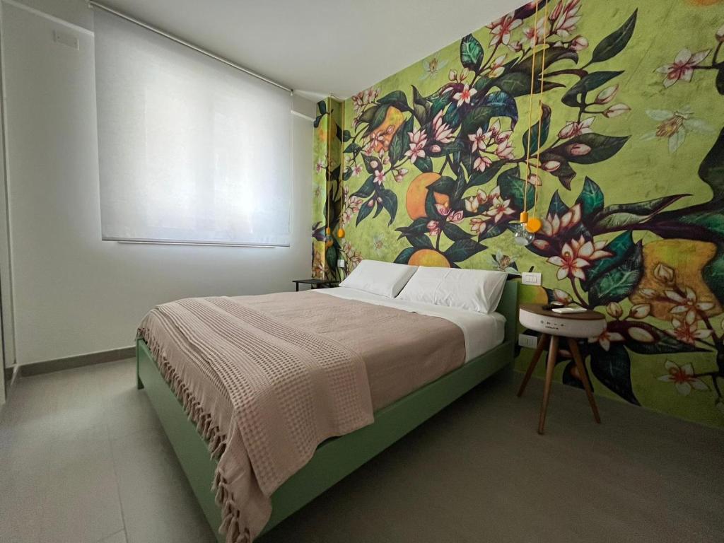 Schlafzimmer mit einem Bett mit Wandgemälde in der Unterkunft 'Na Pace dei Santi B&B in Porto SantʼElpidio