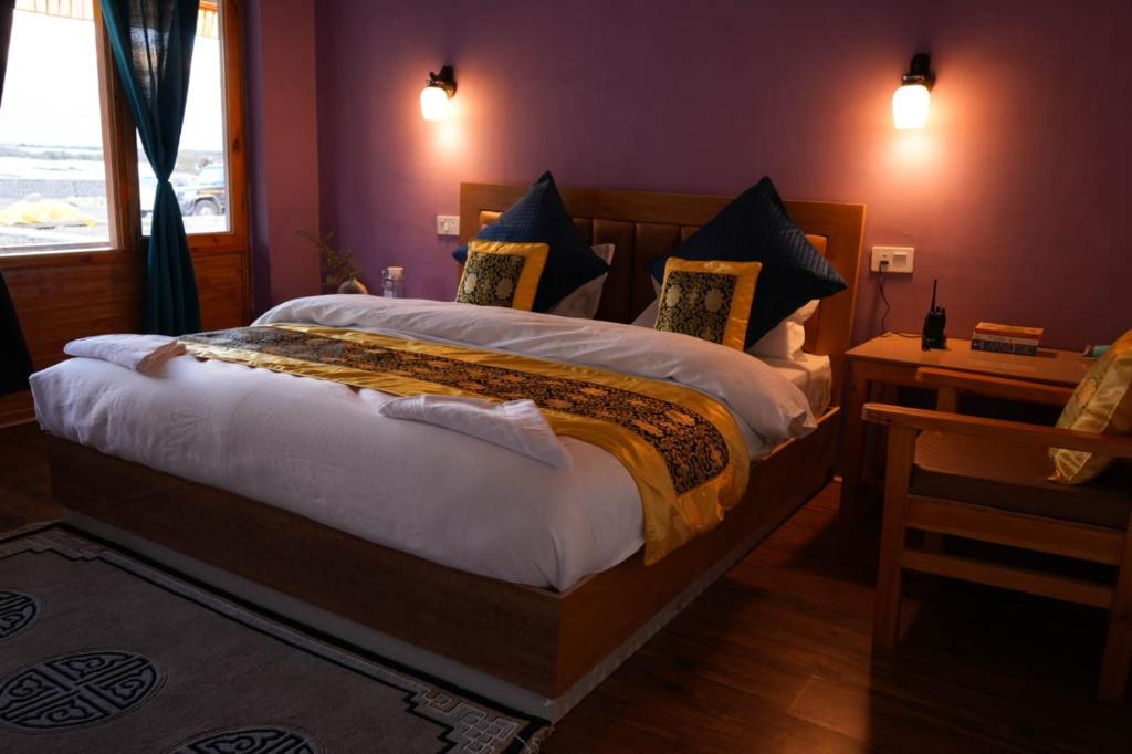 1 dormitorio con 1 cama grande y paredes moradas en THE RIVERSIDE RESORT Hunder, en Leh