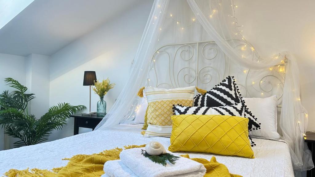 - une chambre avec un lit blanc à baldaquin dans l'établissement Living Puebla, à Pobra do Caramiñal
