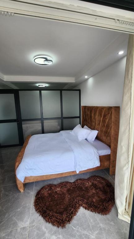 una camera da letto con un grande letto con lenzuola bianche di Gatundu Heights a Nairobi