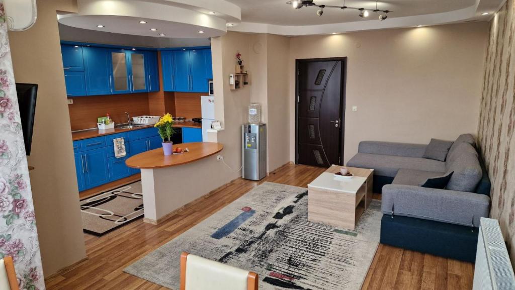 a kitchen and a living room with blue cabinets at Boutique Apartment Jana in Shumen