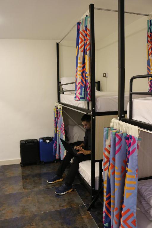 a man sitting on a bed in a bunk room at Amman Trail Hostel in Amman