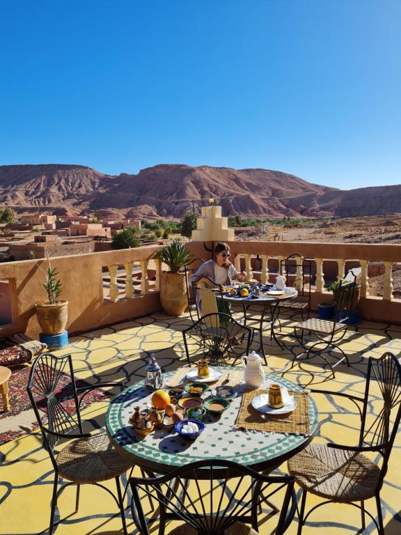 a man sitting at a table with food on a patio at Riad Tigmi du Soleil in Aït Ben Haddou