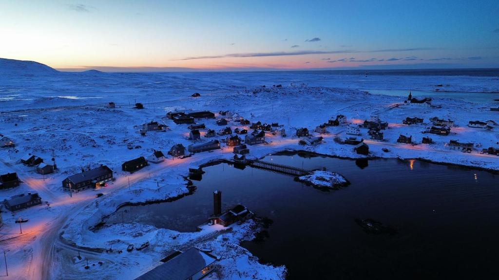 a group of vehicles parked in the snow at Gamvik brakkebo as in Gamvik