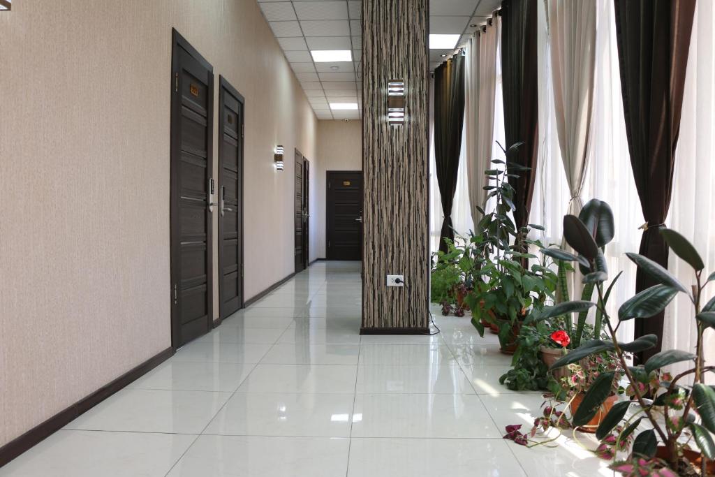 een hal met potplanten en een zuil in een gebouw bij Diamond Hotel Dushanbe in Doesjanbe
