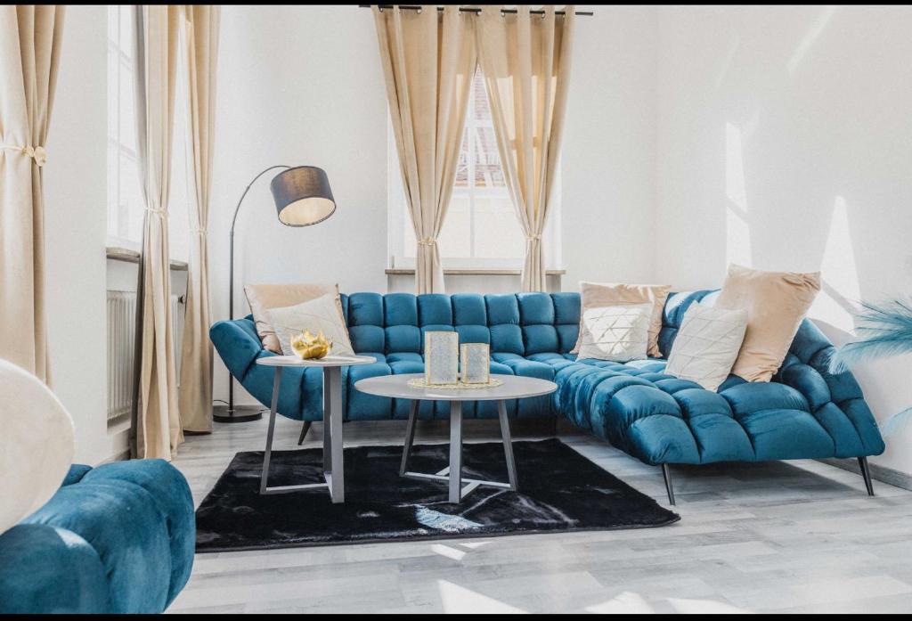 uma sala de estar com um sofá azul e uma mesa em Ferienwohnung Zentrum Erding em Erding