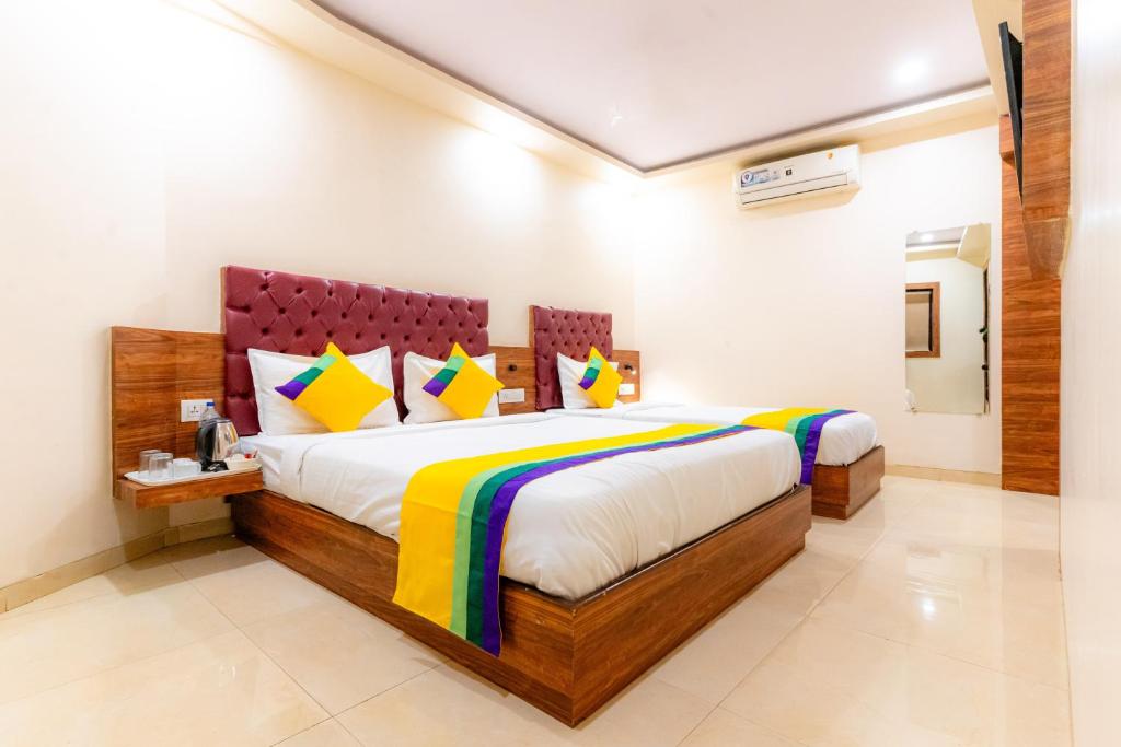 a bedroom with a large bed with colorful pillows at Itsy Hotels Elegant in Mumbai