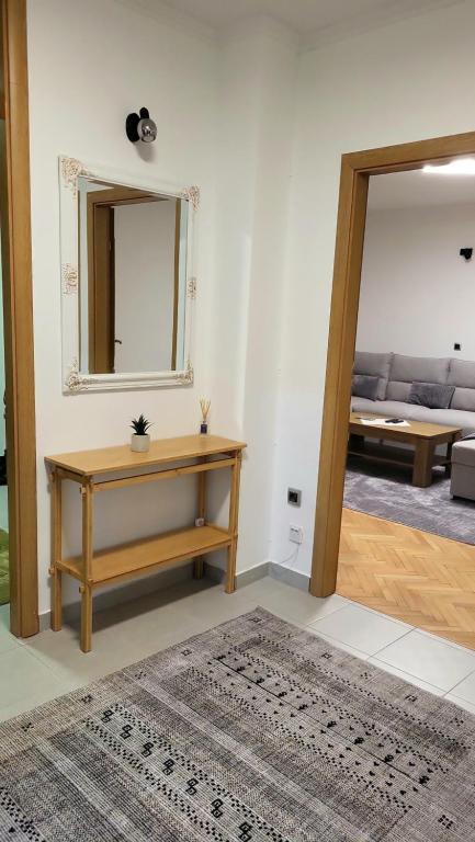een woonkamer met een tafel en een spiegel bij Apartment Urban Nest in Zenica