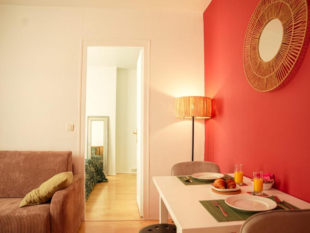 uma sala de estar com uma mesa e uma parede vermelha em FLOWER - Métro à 6 minute em Vanves