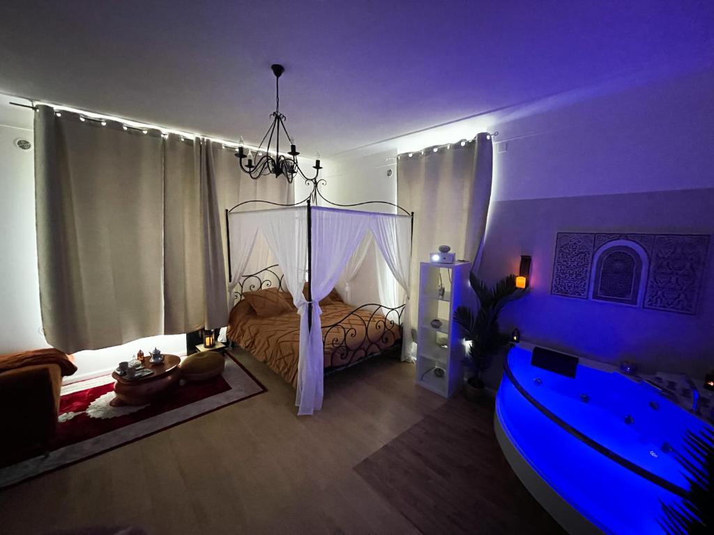 Dormitorio con cama con dosel en habitación púrpura en Appartement avec Balneo - Casa casbah, en Saint-Ouen