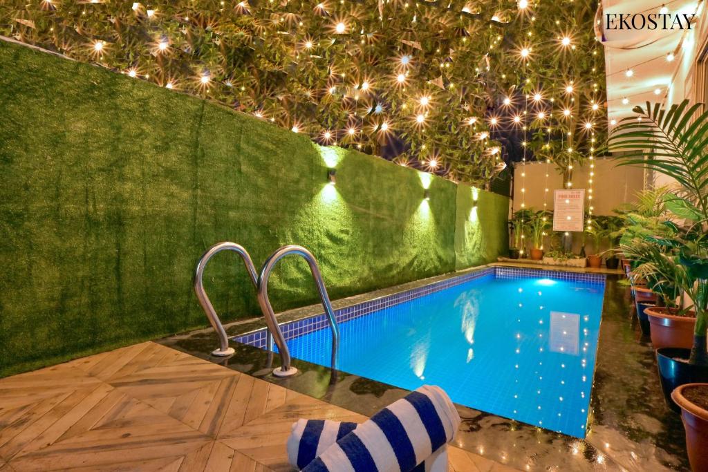 a swimming pool in a room with lights at EKOSTAY - Omega Villa in Igatpuri