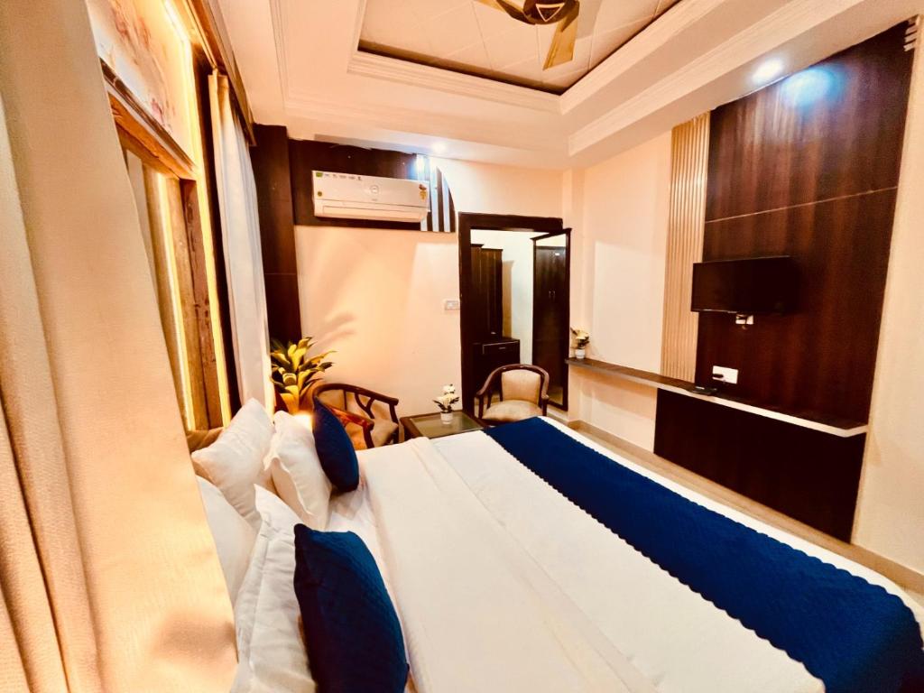 ein Hotelzimmer mit einem großen Bett mit blauen Kissen in der Unterkunft Hotel Ramawati Near Ganga Ghat in Haridwar