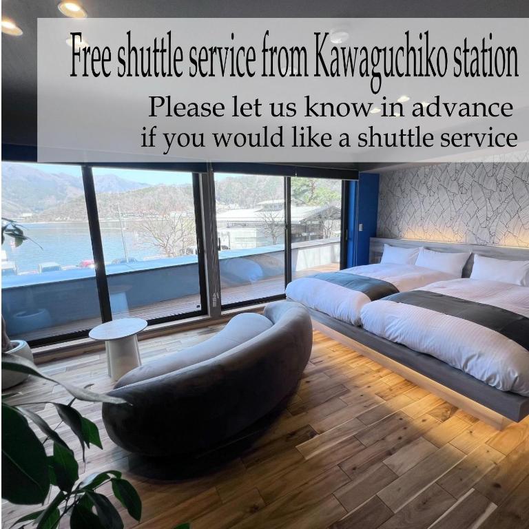 a bedroom with two beds and a large window at SAZANAMI LAKE FRONT in Fujikawaguchiko