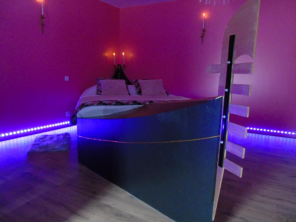 um quarto com uma cama num quarto roxo em love room La gondole du plaisir em Saint-Pierre-dʼAmilly