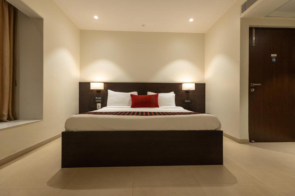 a bedroom with a large bed with a red pillow at Freesia Residency by Express Inn in Nashik