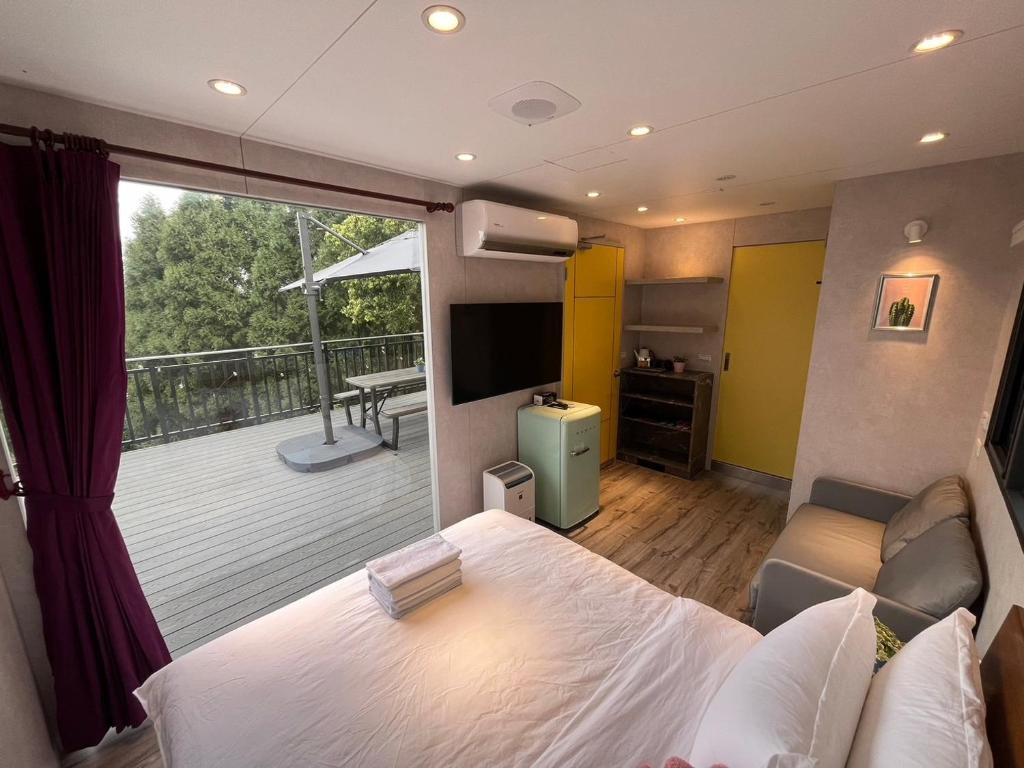 南庄的住宿－山田民宿，一间带大床的卧室和一个阳台