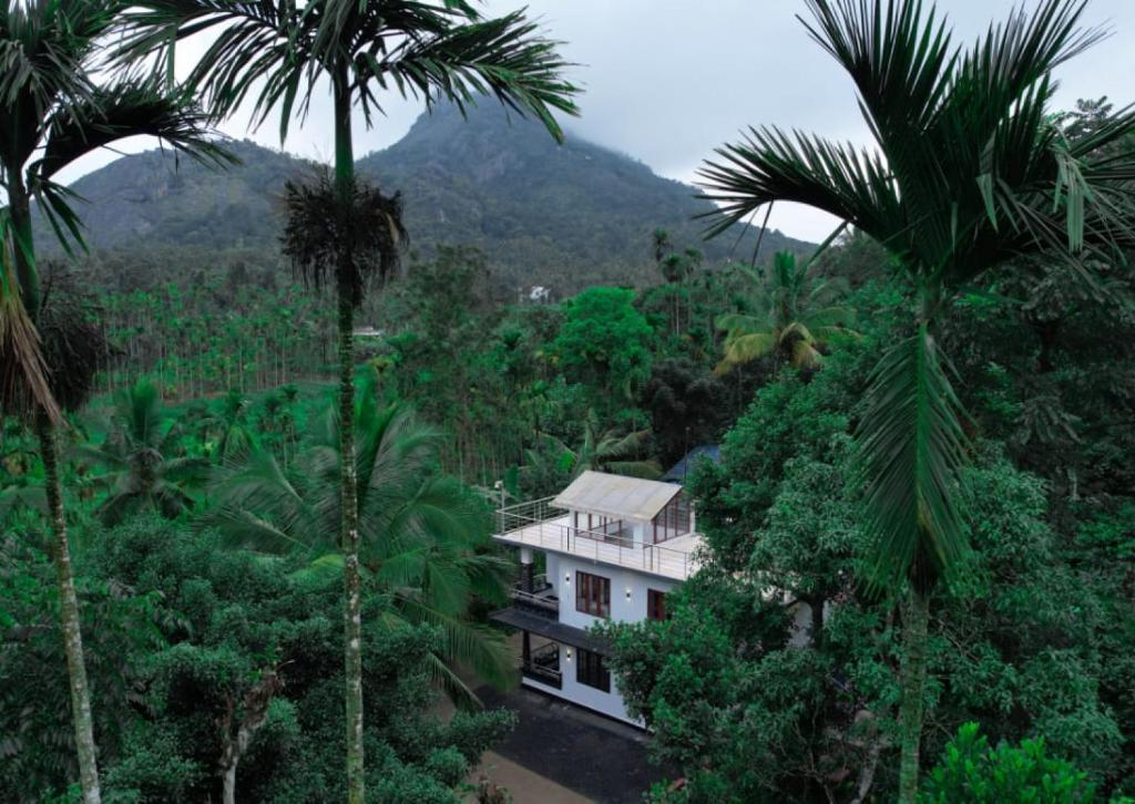 una casa en medio de un bosque con palmeras en Shivas Farmhouse, en Sultan Bathery