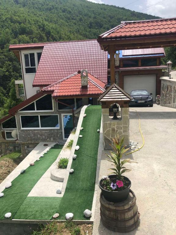 uma casa com um relvado verde em frente a uma casa em Vila Djekic em Andrijevica