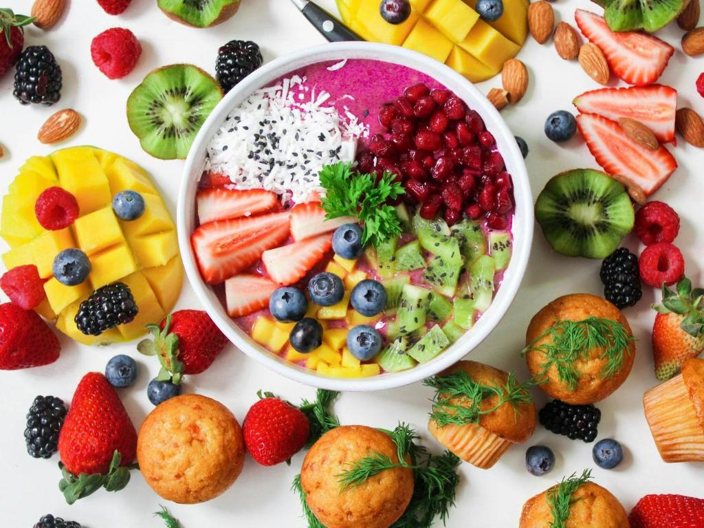 a table filled with fruit and a bowl of fruit salad at Hotel Irshad ji in New Delhi