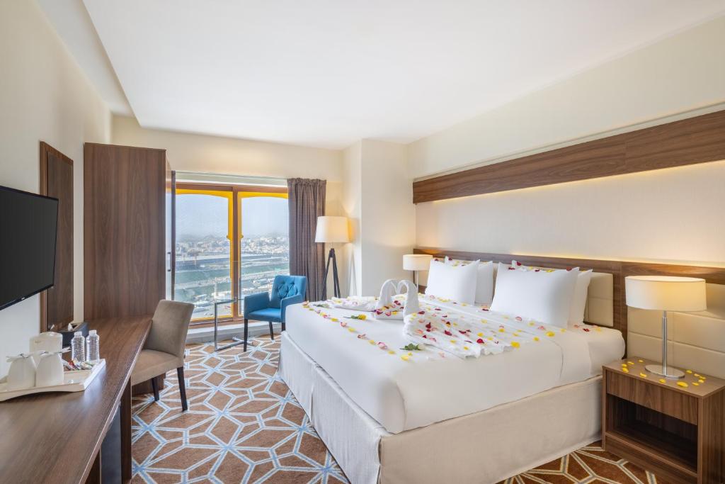 a hotel room with a large bed and a desk at Blue Coral Hotel in Makkah