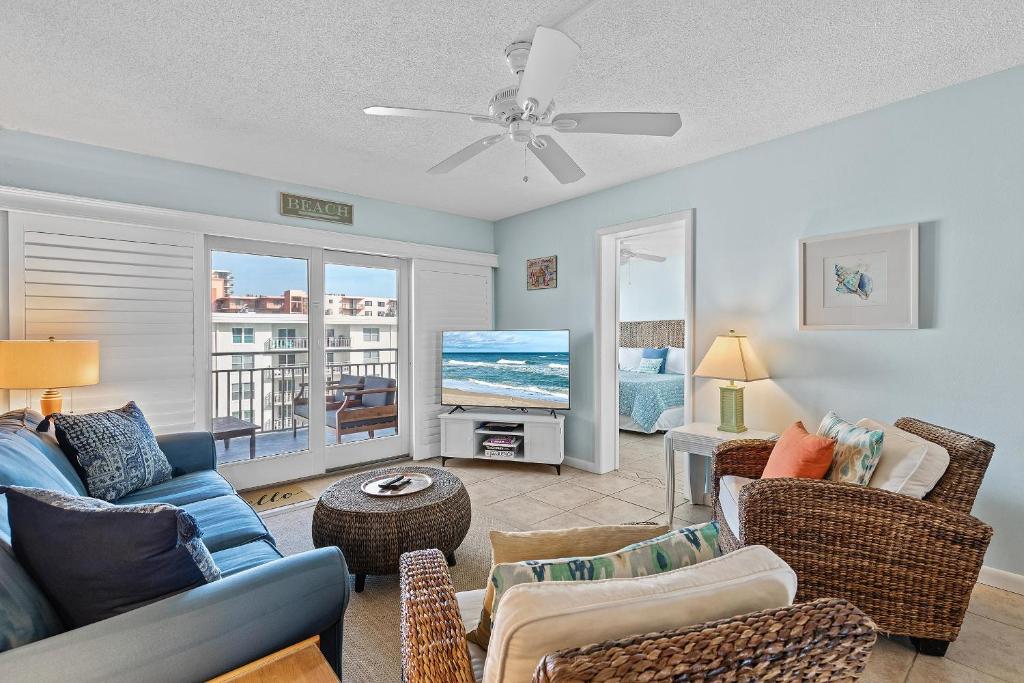 Sea Coast Gardens III 513 في نيو سميرنا بيتش: غرفة معيشة مع أريكة وكراسي وتلفزيون