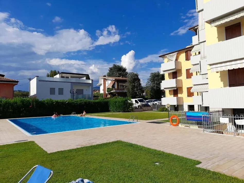 a swimming pool in a yard next to a building at Caba Holiday Bardolino Pasubio in Bardolino