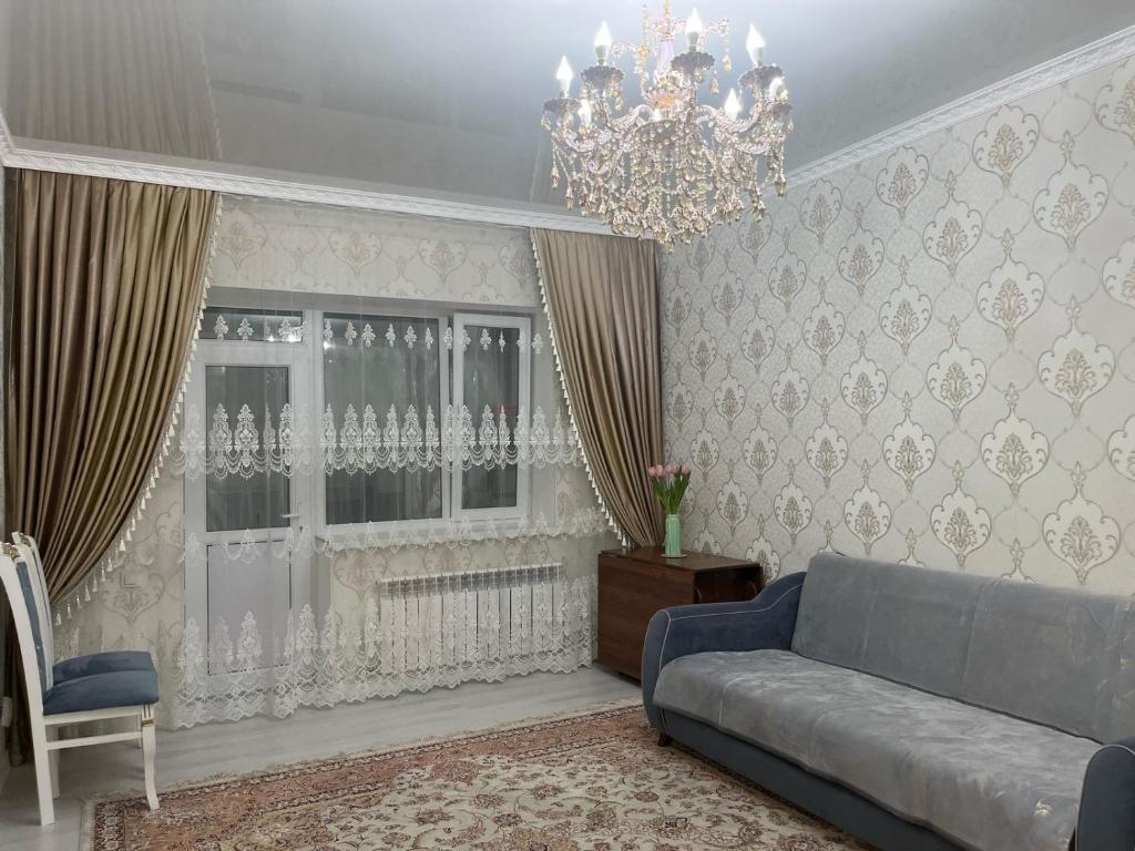 a living room with a couch and a chandelier at 3-комнатные Апартаменты LUX in Taraz