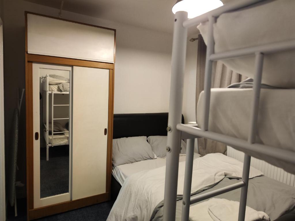 a bedroom with a bunk bed and a mirror at home from home in Erith