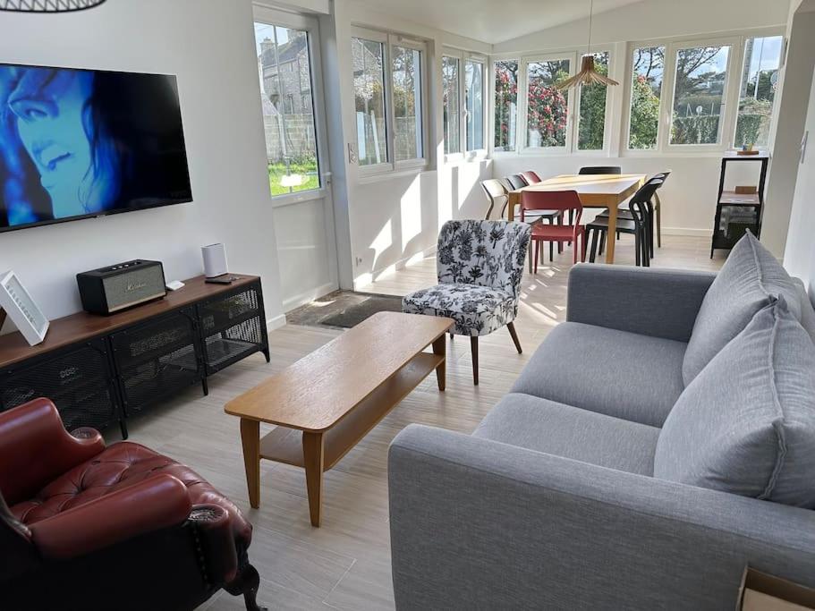 a living room with a couch and a tv and a table at Pied à terre Portsallais in Ploudalmézeau