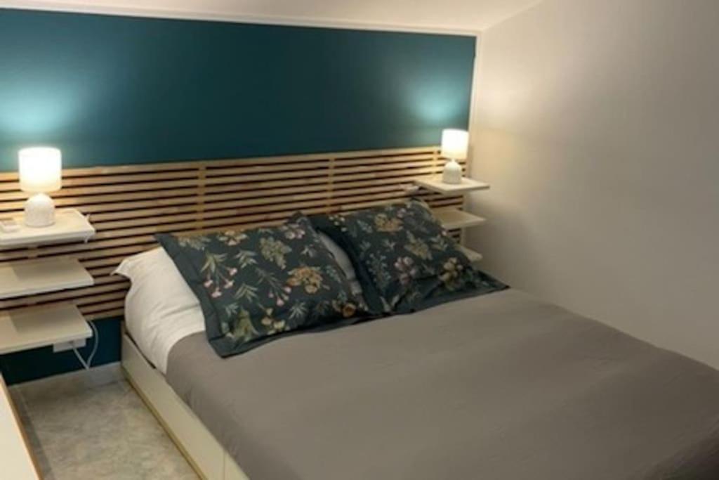 - une chambre avec un grand lit et deux lampes dans l'établissement Appartamento incantevole, Soverato, à Soverato Marina