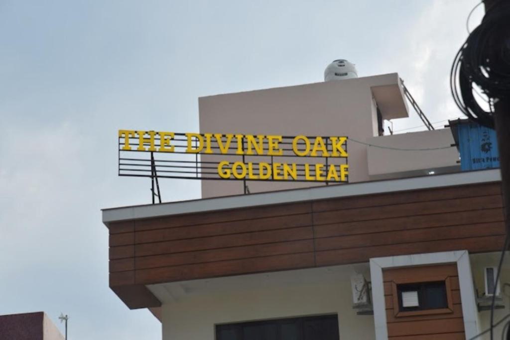 a building with a sign on top of it at The Divine Oak Golden Leaf , Katra in Katra