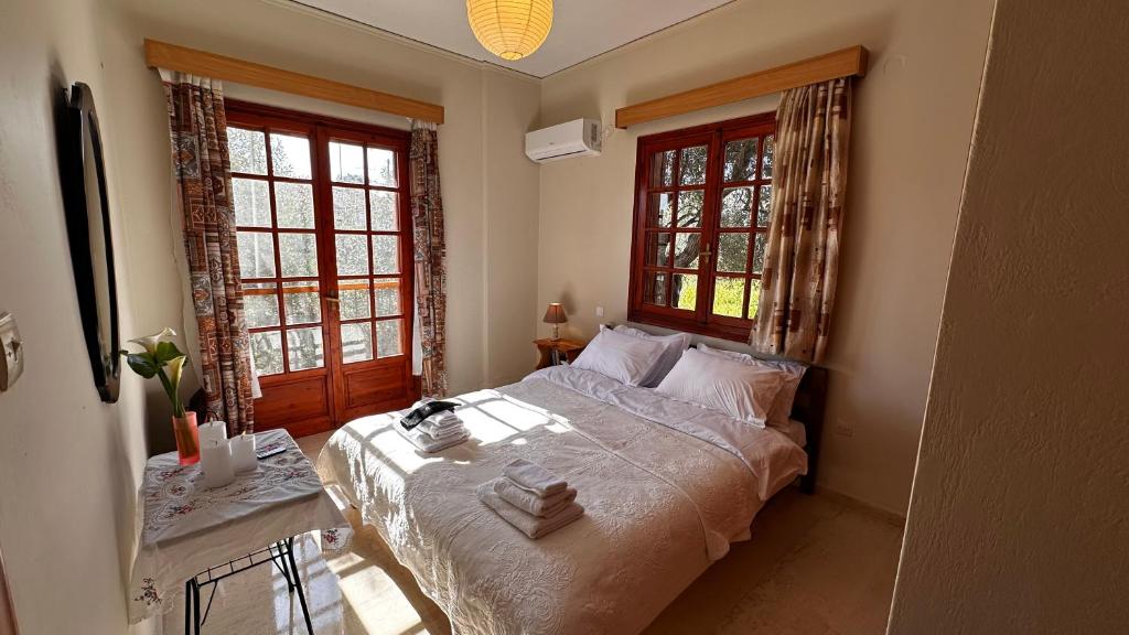 a bedroom with a large bed and two windows at Holiday apartment near the sea in Melission