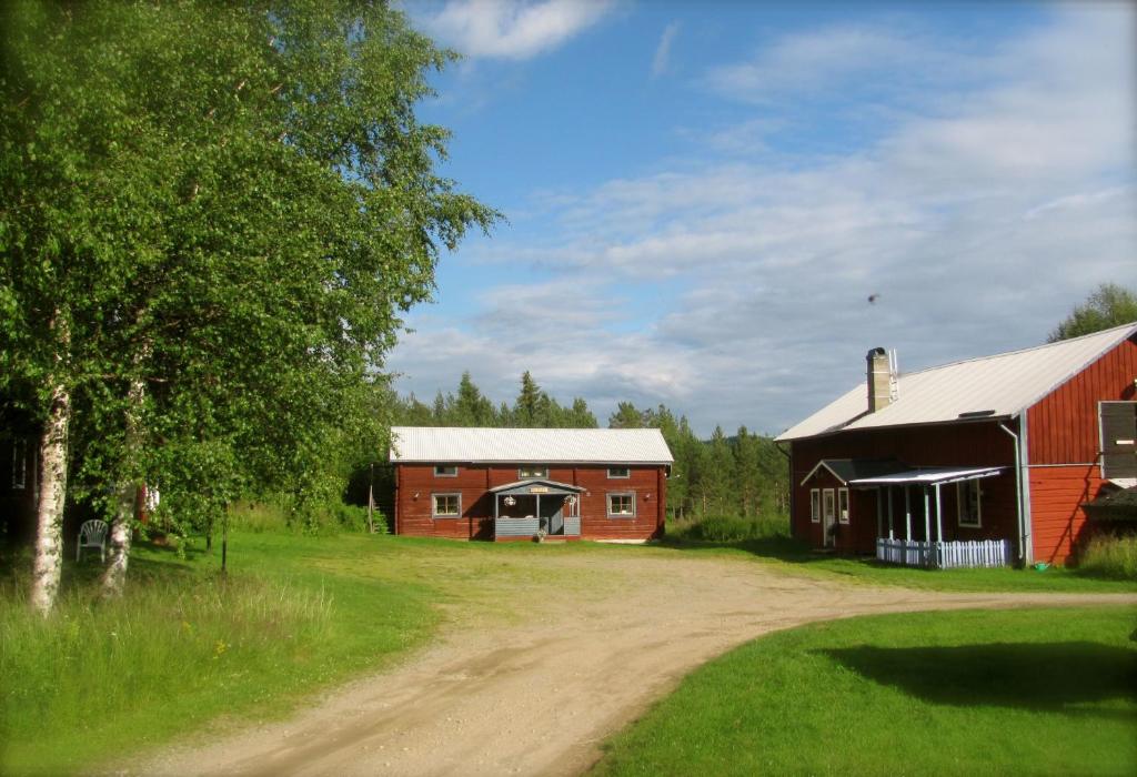 een onverharde weg naast een rode schuur bij Ellis Gården in Vemhån