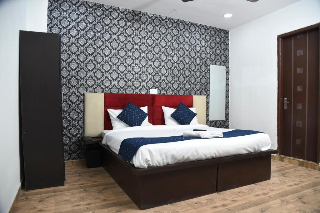 um quarto com uma cama grande e uma cabeceira vermelha em Hotel Orchid INN at Budget Bazaar Janakpuri em Nova Deli