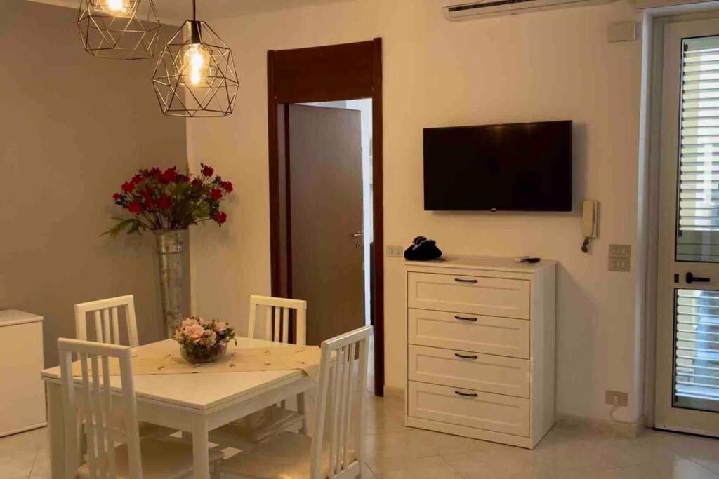 een eetkamer met een tafel en een televisie bij Appartamento centrale a Soverato in Soverato Marina