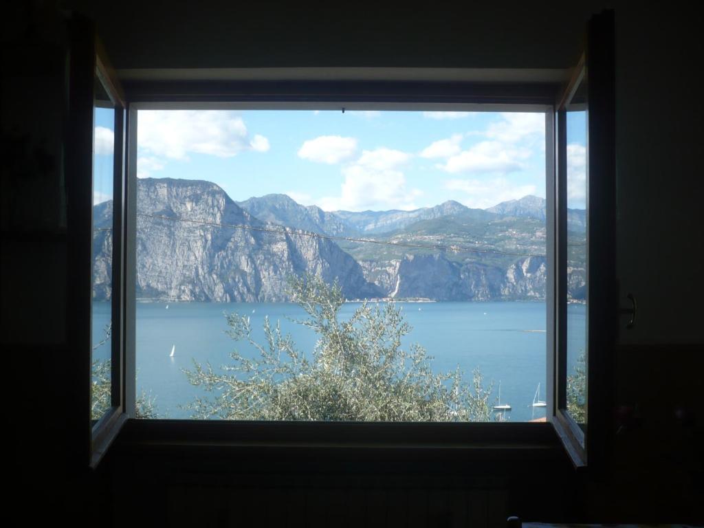 a window with a view of the water and mountains at Appartamento Michela in Brenzone sul Garda