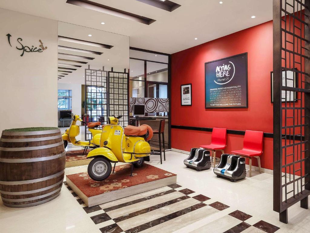 a yellow scooter in a room with red walls at ibis Pune Viman Nagar - An Accor Brand in Pune