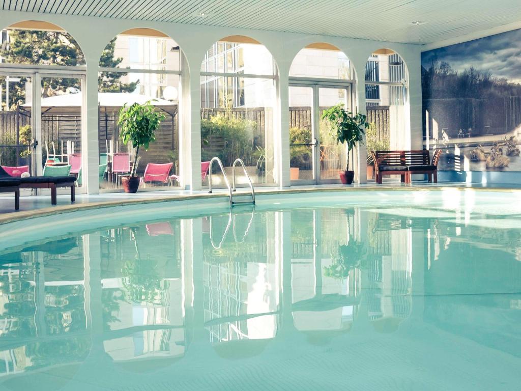 a swimming pool in a building with a pool at Mercure Paris Velizy in Vélizy-Villacoublay