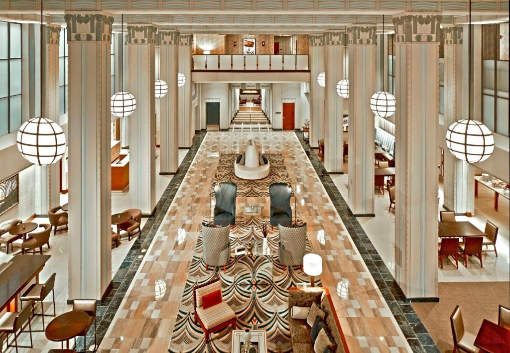 a large lobby with chairs and tables in a building at Hilton Garden Inn Phoenix Downtown in Phoenix