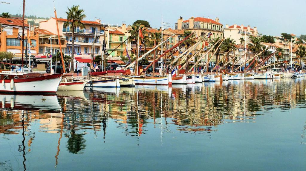 un gruppo di imbarcazioni ormeggiate in un porto con edifici di VILLA BANDOL PROCHE du PORT et DES PLAGES a Bandol