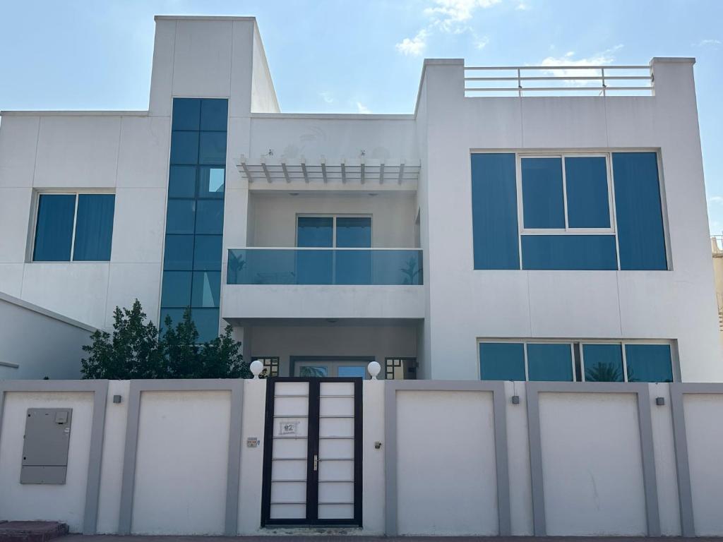 une maison blanche avec une clôture devant elle dans l'établissement Centerpoint Duplex Villa, à Dubaï