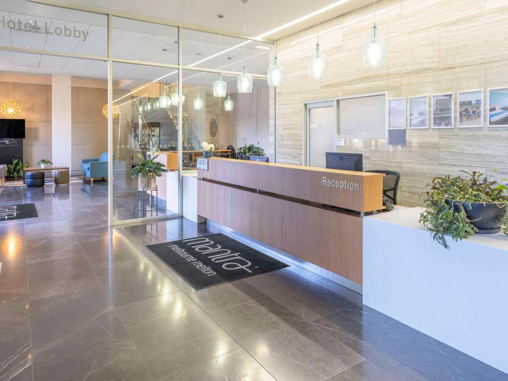 an office lobby with a reception desk and potted plants at Mantra Melbourne Melton in Melton